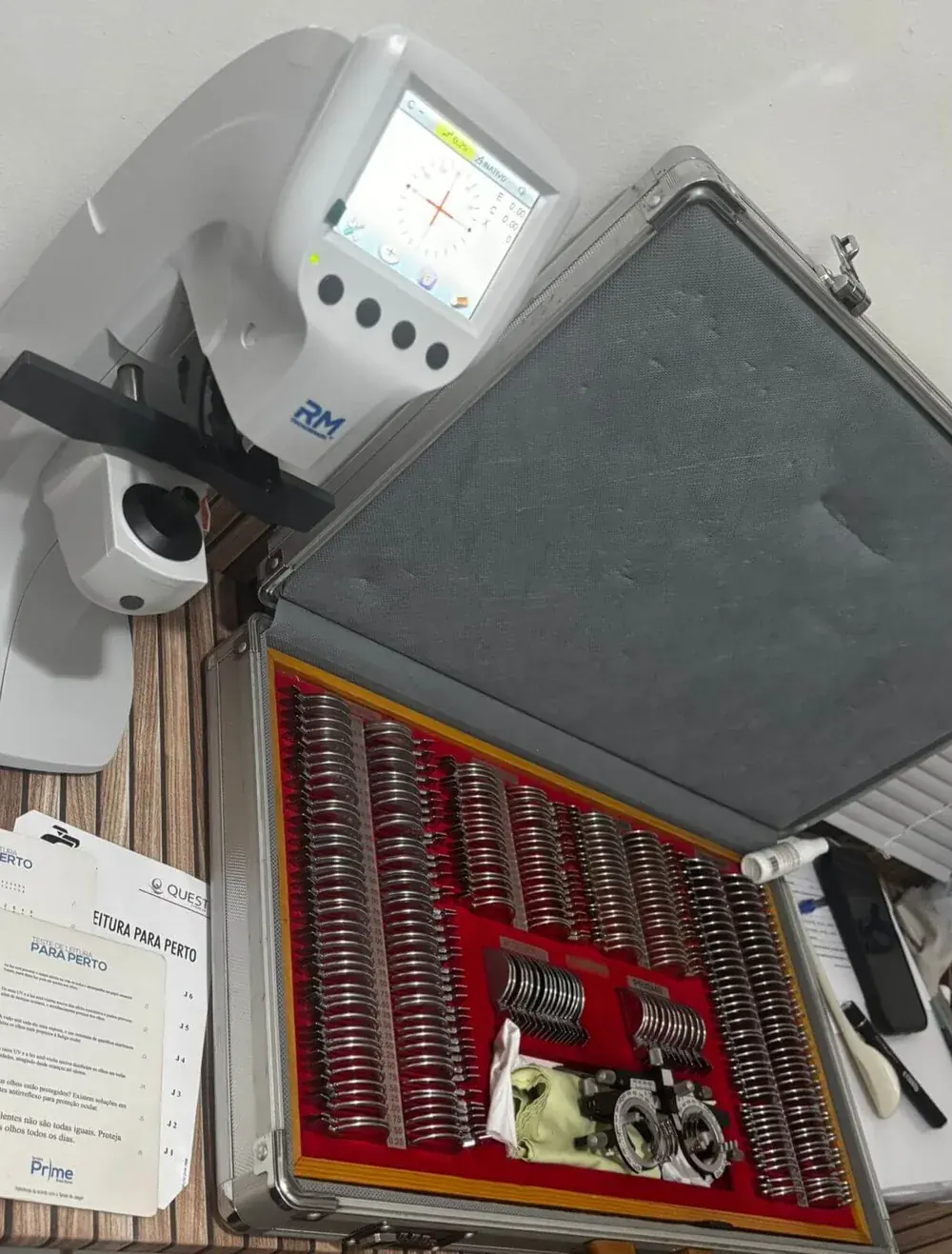 Autorrefrator e caixa de lentes de prova usados no exame de vista da Óptica Visualisi, Porto Alegre