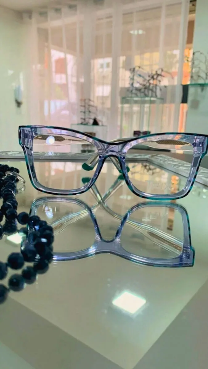 Armação de óculos de grau em acetato azul claro translúcido na vitrine da Óptica Visualisi, Porto Alegre