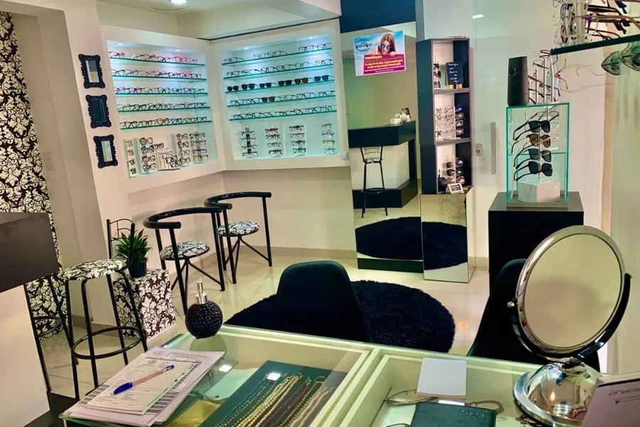 Ambiente interno da Óptica Visualisi com expositores, espelho e área de provas, Porto Alegre