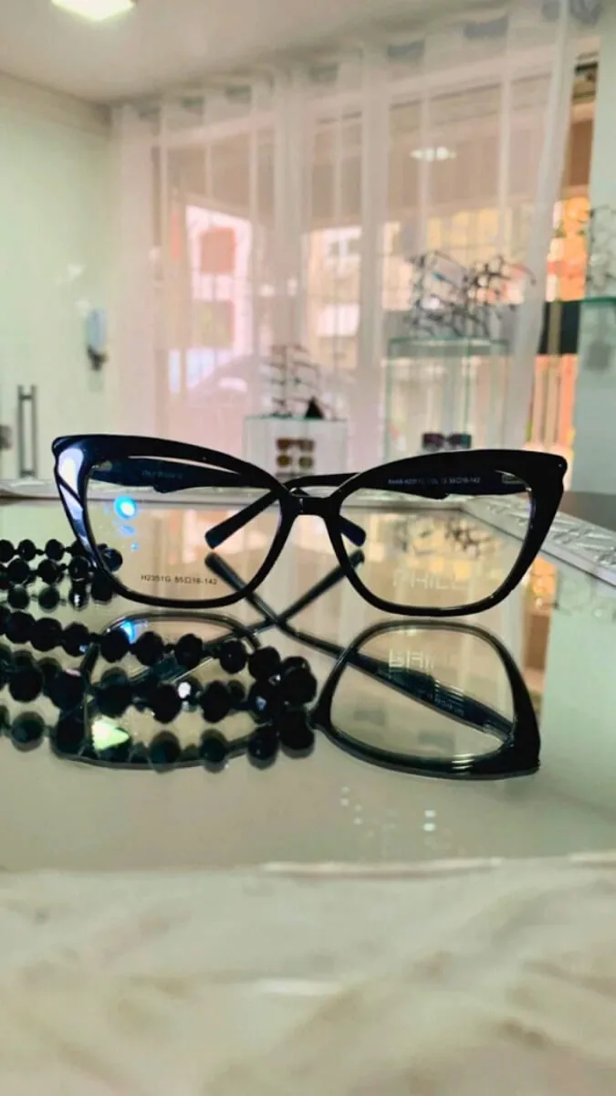Armação de óculos de grau preta em acetato sobre a vitrine da Óptica Visualisi, Porto Alegre