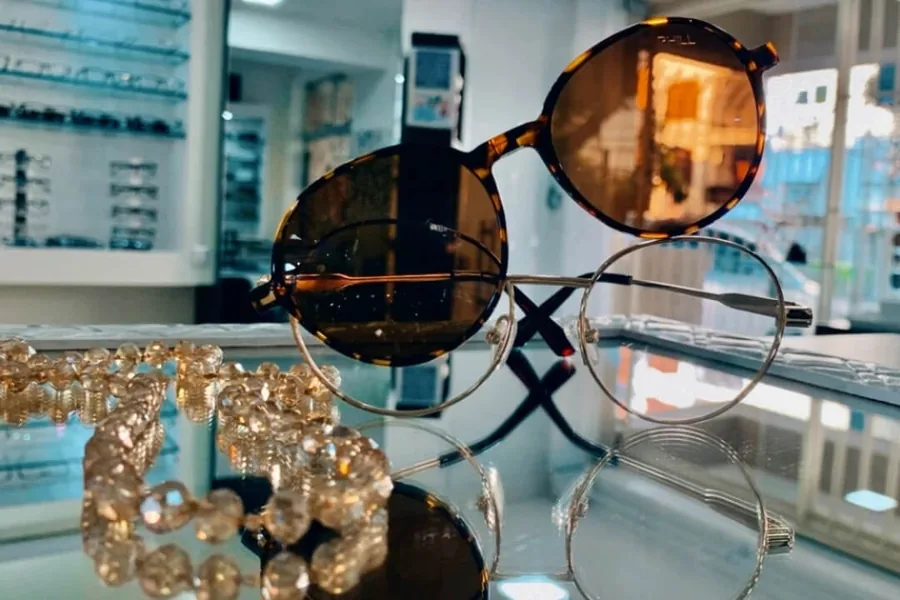 Óculos de sol redondo com armação de metal e lentes marrons na vitrine da Óptica Visualisi, Porto Alegre